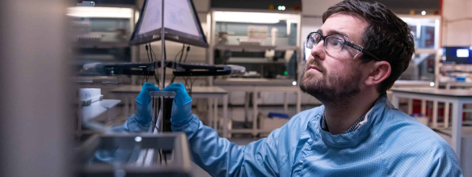 A scientist looks at a machine in the lab