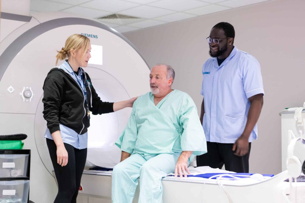 Biobank scanning team with participant on scanner