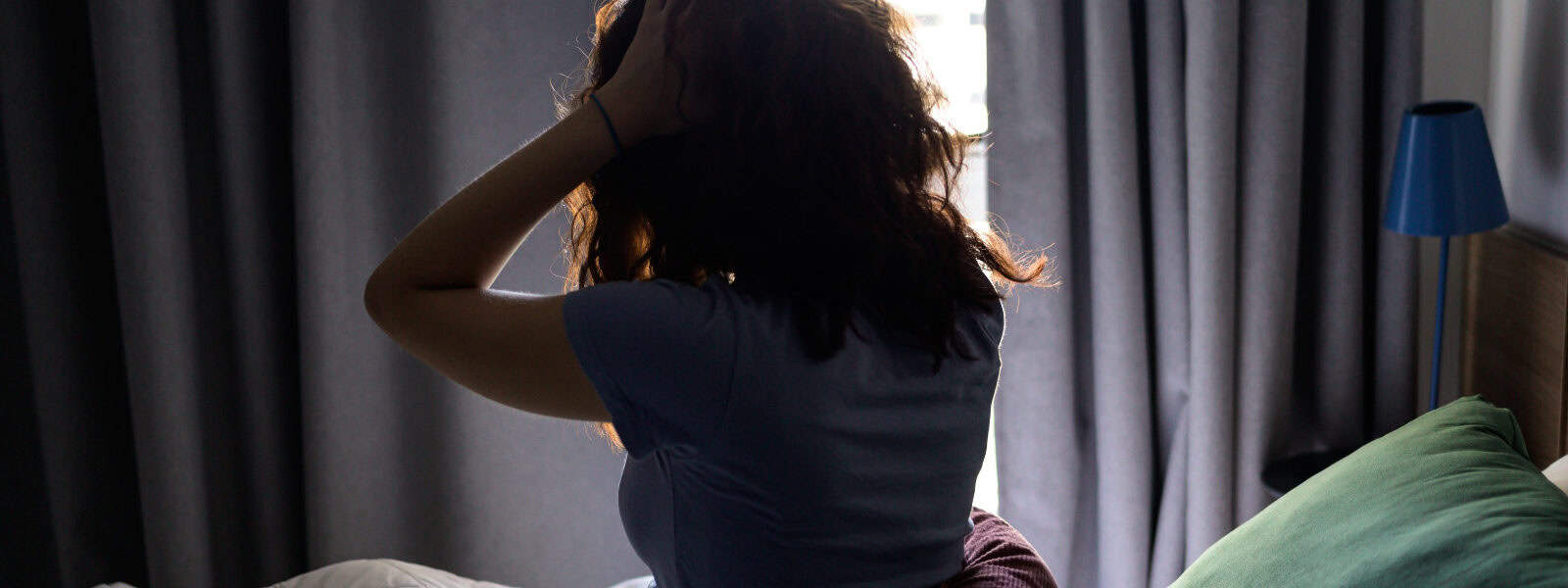 A woman wakes up in bed and stretches