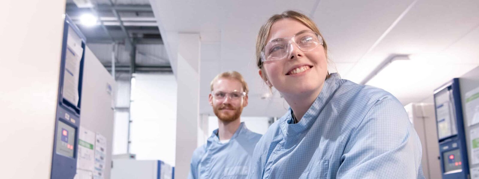 Two scientists smile at the camera