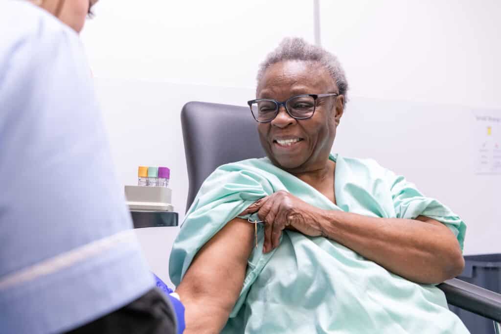 A woman has her blood taken by a nurse