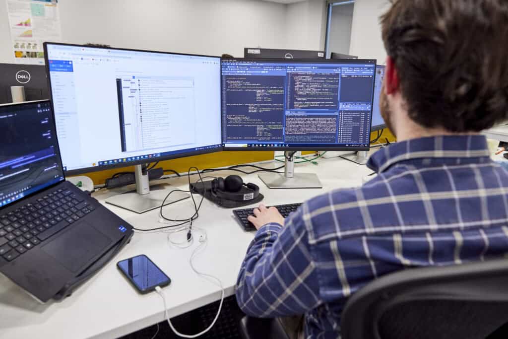 Data analyst looks at lots of data fields on his computer monitor