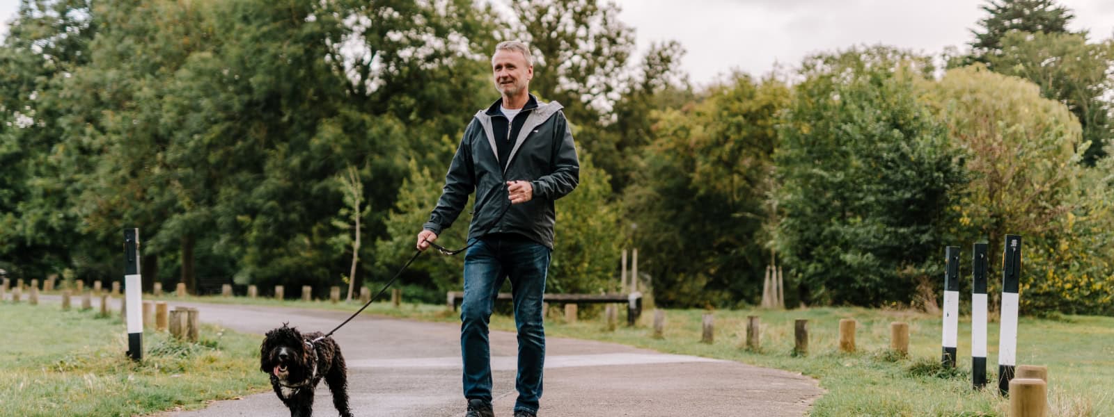 A man walks his dog in the park