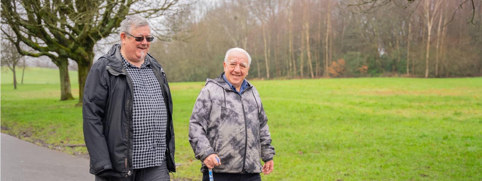 Two men walk through a park